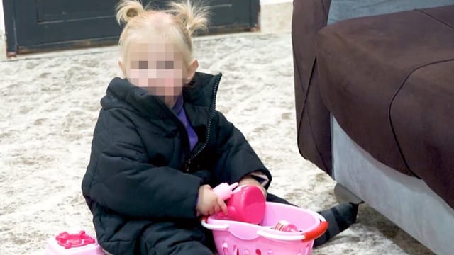 Spielendes Kind sitzt am Boden (Gesicht gepixelt). Spielendes Kind sitzt am Boden (Gesicht gepixelt).