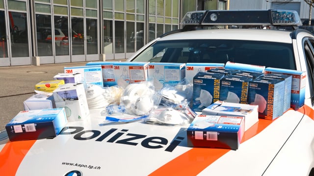 Masken auf der Kühlerhaube eines Polizeiautos Masken auf der Kühlerhaube eines Polizeiautos