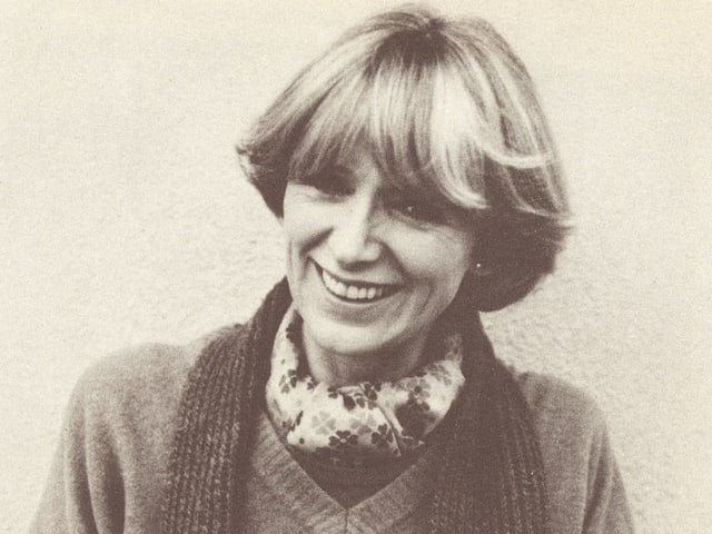 Porträt der blondhaarigen Moderatorin, die einen Strickpullover und einen Schal trägt. Porträt der blondhaarigen Moderatorin, die einen Strickpullover und einen Schal trägt.