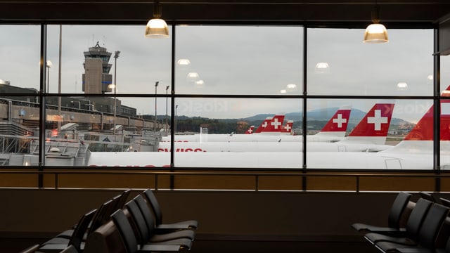 Blick aus einem Fenster des Flughafens Zürich auf stehende Flugzeuge. Blick aus einem Fenster des Flughafens Zürich auf stehende Flugzeuge.