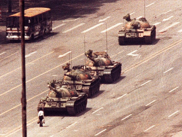 Mann steht vor Panzerkolonne