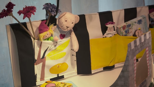 Am Arbeitstisch für die Kinder hängen ganz viele Stofftaschen für Stifte, Büchlein und andere Spielsachen. Am Arbeitstisch für die Kinder hängen ganz viele Stofftaschen für Stifte, Büchlein und andere Spielsachen.