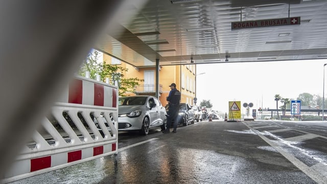 Schweizer Grenzwächter kontrolliert Autos am Grenzposten. Schweizer Grenzwächter kontrolliert Autos am Grenzposten.