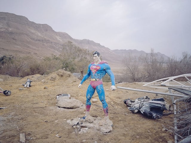 Eine Superman-Figur steht auf einem Minenfeld. Eine Superman-Figur steht auf einem Minenfeld.