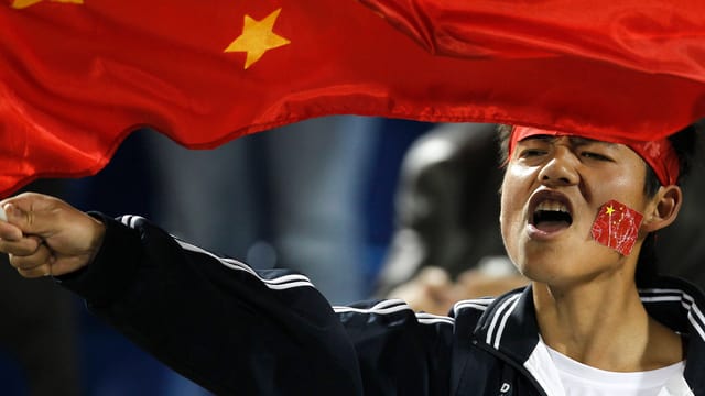 Ein chinesischer Fan feuert sein Team an Ein chinesischer Fan feuert sein Team an
