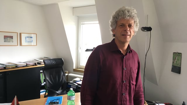 Porträt von Kreisschulpflege-Präsident Urs Berger in seinem Büro. Weisse Haare, rotes Hemd. Porträt von Kreisschulpflege-Präsident Urs Berger in seinem Büro. Weisse Haare, rotes Hemd.