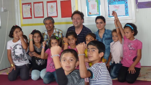 Kinder strecken ihre Arme mit den Armbändern in die Höhe. Kinder strecken ihre Arme mit den Armbändern in die Höhe.