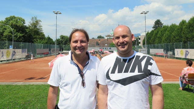 2 Männer stehen von einem Tennisplatz 2 Männer stehen von einem Tennisplatz