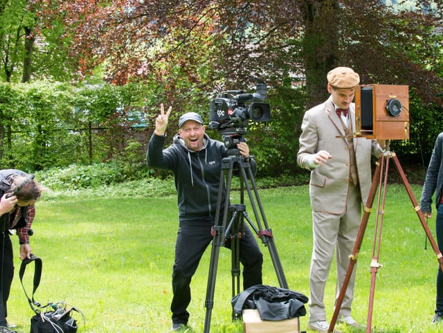 Moderne Kamera hinter historischem Fotoapparat, Kameramann und Fotograf