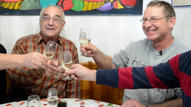 Personen stossen mit einem Glas Weisswein an. Personen stossen mit einem Glas Weisswein an.