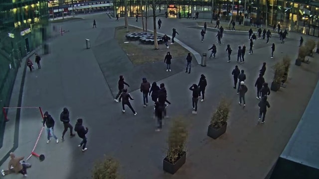 Schwarz gekleidete Gestalten auf einem Platz. Schwarz gekleidete Gestalten auf einem Platz.