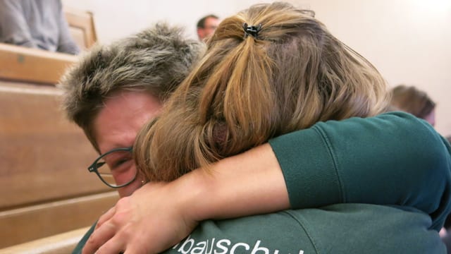 Zwei Frauen liegen sich in den Armen Zwei Frauen liegen sich in den Armen