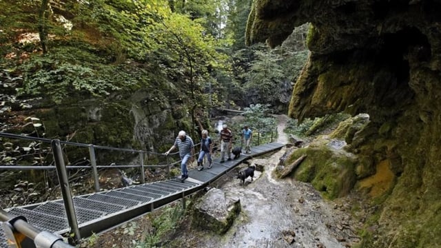 Wanderer unterwegs auf einem Metallsteg in der Schlucht Wanderer unterwegs auf einem Metallsteg in der Schlucht