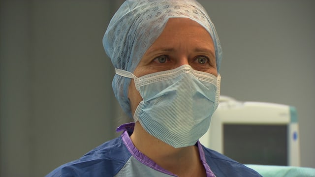 Die Ärztin mit Gesichtsmaske im Operationssaal. Operieren ist für Stephanie von Orelli wie ein Kunsthandwerk Die Ärztin mit Gesichtsmaske im Operationssaal. Operieren ist für Stephanie von Orelli wie ein Kunsthandwerk
