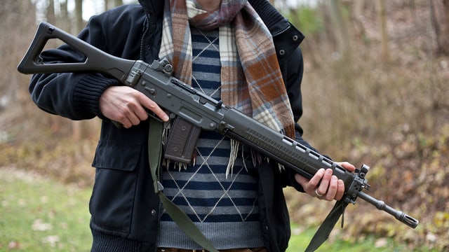Mann hält Sturmgewehr Mann hält Sturmgewehr
