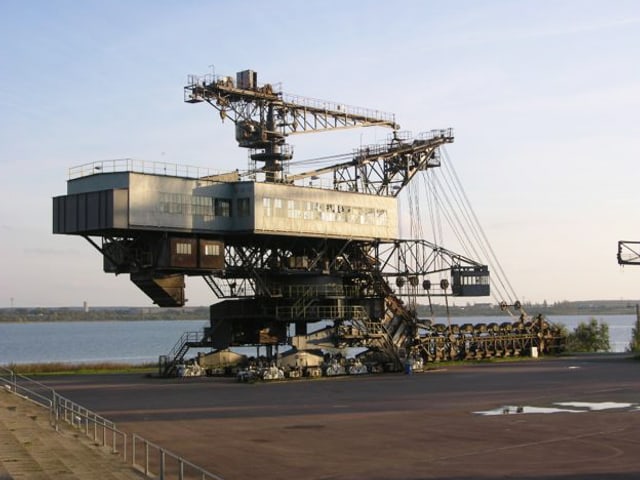 Blick auf eine grosse industrielle Maschine am Wasser Blick auf eine grosse industrielle Maschine am Wasser