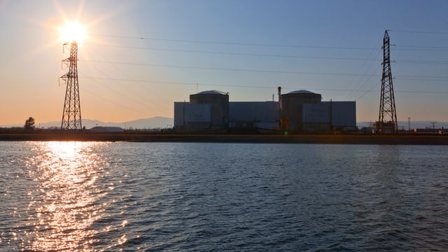 Die Sonne steht über dem Atomkraftwerk Fessenheim am Rhein. Die Sonne steht über dem Atomkraftwerk Fessenheim am Rhein.