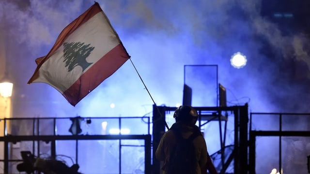 Ein Demonstrant hält eine Libanon-Flagge hoch. Ein Demonstrant hält eine Libanon-Flagge hoch.