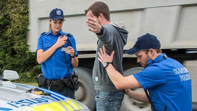 Polizisten bei einer Personenkontrolle Polizisten bei einer Personenkontrolle