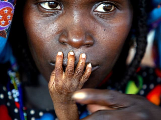 Unternährtes Kind hält seine Hand an den Mutter der Mutter, Niger 2005. Unternährtes Kind hält seine Hand an den Mutter der Mutter, Niger 2005.
