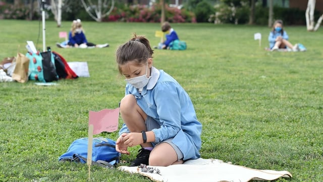 Schulkinder mit Abstand auf einer Wiese Schulkinder mit Abstand auf einer Wiese
