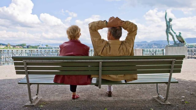 Zwei Personen sitzen auf der Bank. Zwei Personen sitzen auf der Bank.