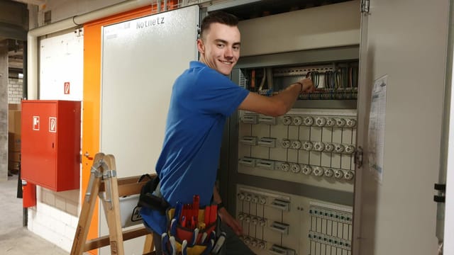 junger Mann arbeitet an einem Elektrokasten. junger Mann arbeitet an einem Elektrokasten.