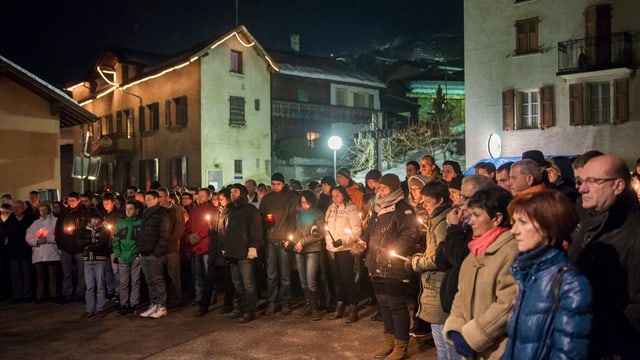 Viele Menschen mit Kerzen auf einem Dorfplatz Viele Menschen mit Kerzen auf einem Dorfplatz
