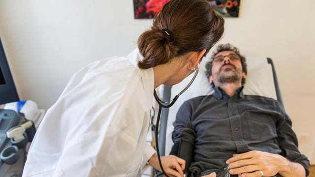 Eine Ärztin untersucht einen Patienten. Eine Ärztin untersucht einen Patienten.