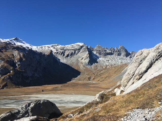 Die karge Segnes-Ebene mit einem wolkenlosen Himmel. Auf den Bergen liegt kaum Schnee.