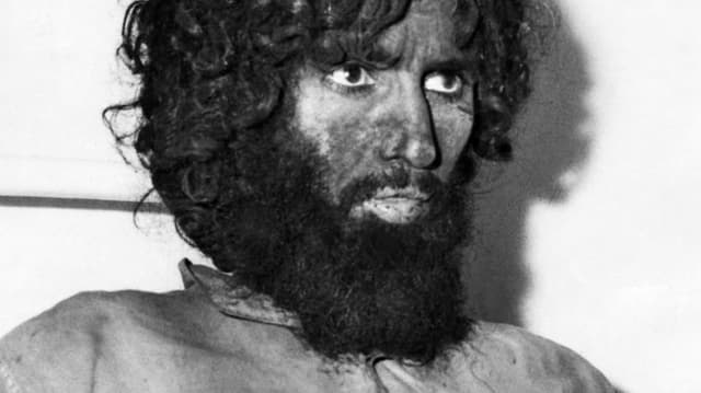 Juhayman al-Otaybi trägt einen Bart. Er hat Dreck im Gesicht. Juhayman al-Otaybi trägt einen Bart. Er hat Dreck im Gesicht.