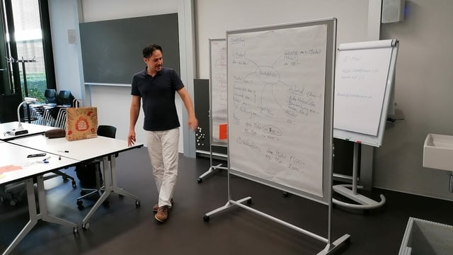Mann vor einer beschriebenen Tafel Mann vor einer beschriebenen Tafel