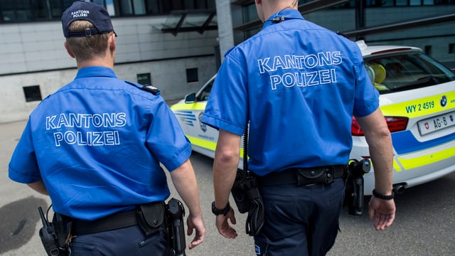 Polizisten laufen neben Streifenwagen vorbei Polizisten laufen neben Streifenwagen vorbei