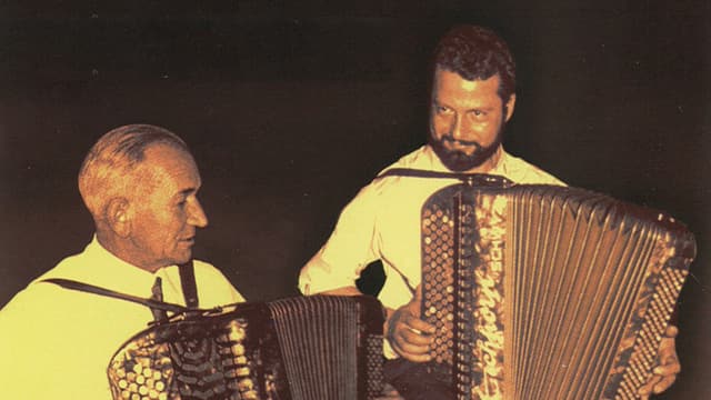 Die beiden Musiker spielen sitzend auf dem Akkordeon. Die beiden Musiker spielen sitzend auf dem Akkordeon.