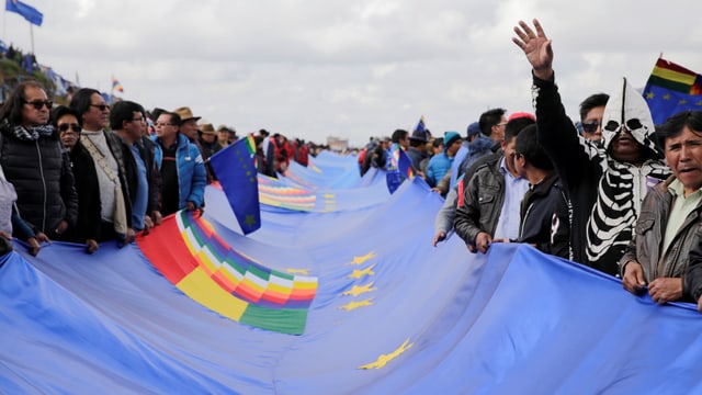 Bolivianer halten ein blaues Banner Bolivianer halten ein blaues Banner