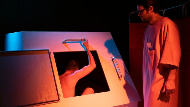 Ein Theaterbesucher steigt nackt in einen Kasten. Ein Theaterbesucher steigt nackt in einen Kasten.