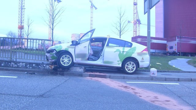 Taxi frontal im Geländer, auslaufendes Öl mit Bindemittel auf der Strasse Taxi frontal im Geländer, auslaufendes Öl mit Bindemittel auf der Strasse