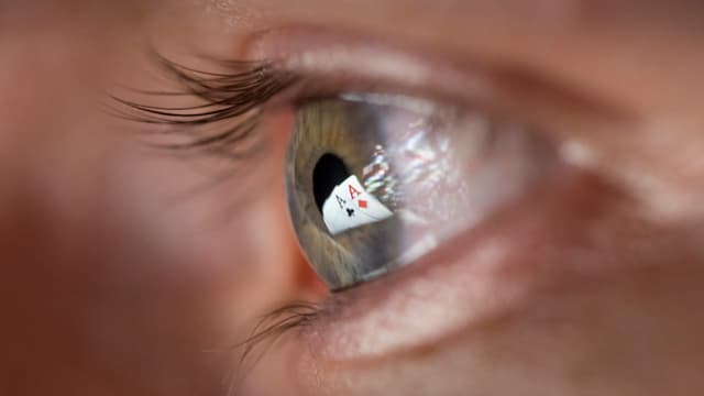 Zwei Pokerkarten-Asse spiegeln sich in einem Auge. Zwei Pokerkarten-Asse spiegeln sich in einem Auge.
