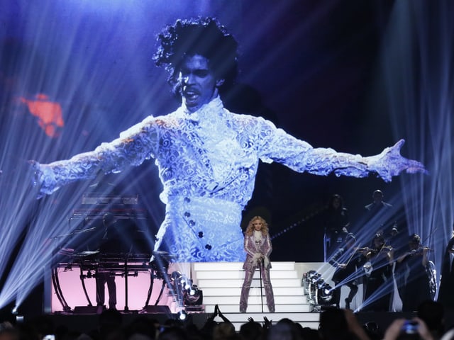 Madonna auf der Bühne vor einer grossen Projektion von Prince Madonna auf der Bühne vor einer grossen Projektion von Prince