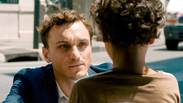 Georg (Franz Rogowski) blickt tief in die Augen eines Kinds. Georg (Franz Rogowski) blickt tief in die Augen eines Kinds.