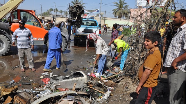 In Diwaniya räumen die Anwohner die Trümmer weg, nachdem in den Morgenstunden eine Autobombe detoniert war. In Diwaniya räumen die Anwohner die Trümmer weg, nachdem in den Morgenstunden eine Autobombe detoniert war.