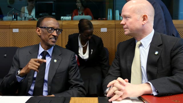 Kagame und Hague sitzen nebeneinander und sind in ein Gespräch vertieft. Kagame und Hague sitzen nebeneinander und sind in ein Gespräch vertieft.