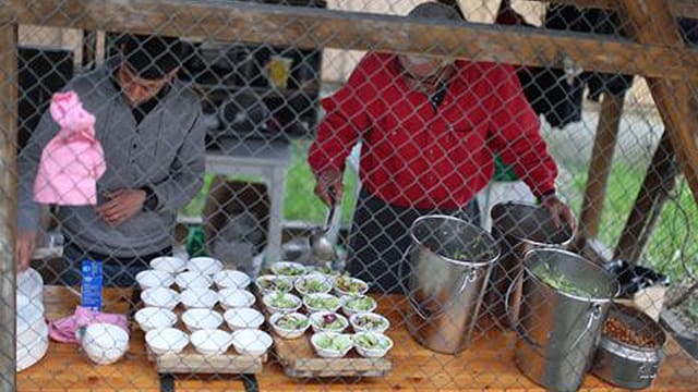 Menschen füllen Essen in Schalen. Menschen füllen Essen in Schalen.
