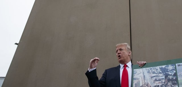 Donald Trump vor einer hohen grauen Betonmauer. Donald Trump vor einer hohen grauen Betonmauer.