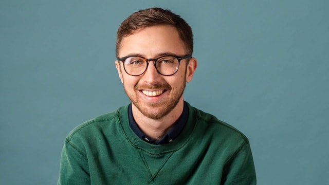 Ein junger Mann mit Brille, lächelnd. Ein junger Mann mit Brille, lächelnd.