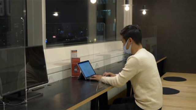 Japaner an einer langen Sitzbank mit Tablet Japaner an einer langen Sitzbank mit Tablet