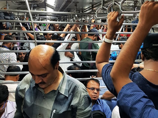 Ein mit Menschen komplett gefüllter Zug von Innen. Viele halten sich fest, einige haben einen Sitzplatz ergattert. Ein mit Menschen komplett gefüllter Zug von Innen. Viele halten sich fest, einige haben einen Sitzplatz ergattert.