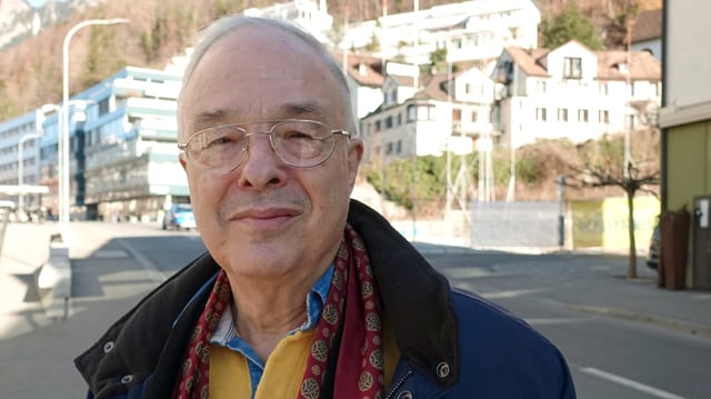 Porträt eines Mannes, im Hintergrund Strasse und Häuser Porträt eines Mannes, im Hintergrund Strasse und Häuser
