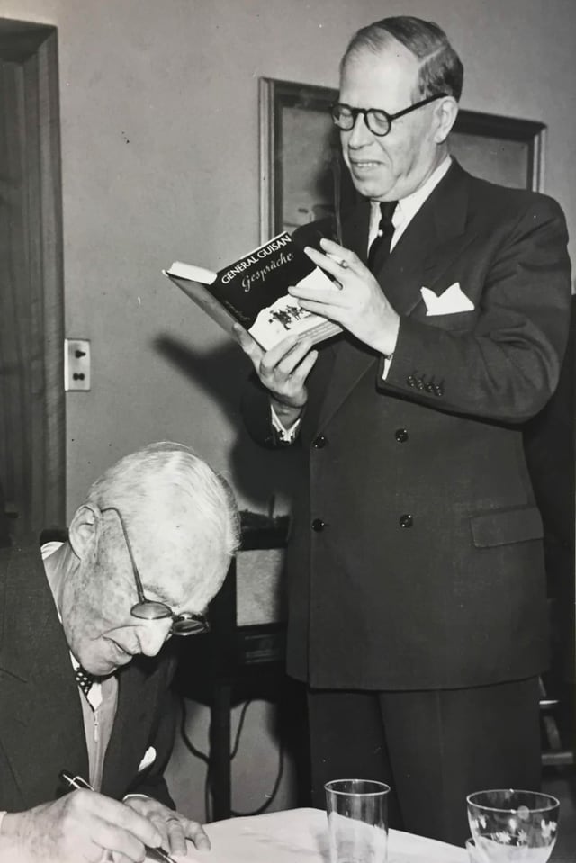 Zwei Männer, einer steht und liest ein Buch. Der andere schreibt etwas. Zwei Männer, einer steht und liest ein Buch. Der andere schreibt etwas.