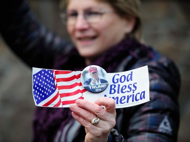 Frau mit Trump-Button und Wahlwerbung in der Hand. Frau mit Trump-Button und Wahlwerbung in der Hand.